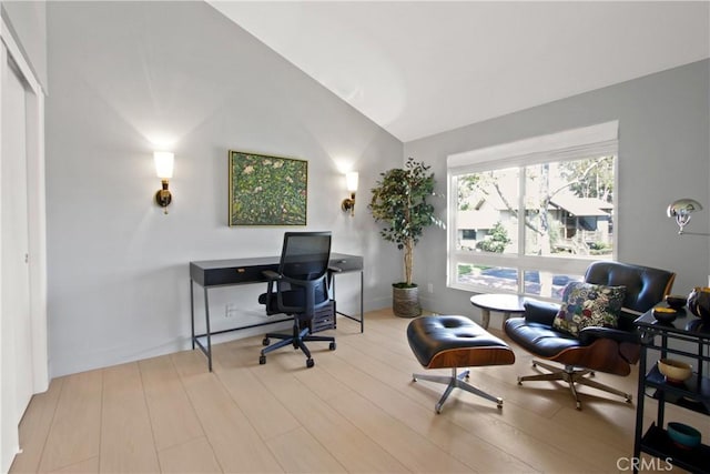 home office featuring vaulted ceiling and light hardwood / wood-style flooring