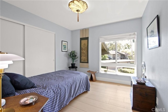 bedroom with a closet and light hardwood / wood-style floors