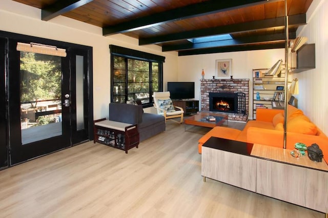 living room with a fireplace, light hardwood / wood-style flooring, beamed ceiling, and wooden ceiling