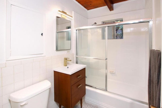 full bathroom with combined bath / shower with glass door, vanity, toilet, and tile walls