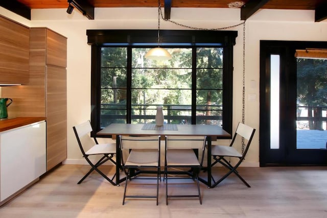 dining space with beam ceiling and light wood-type flooring