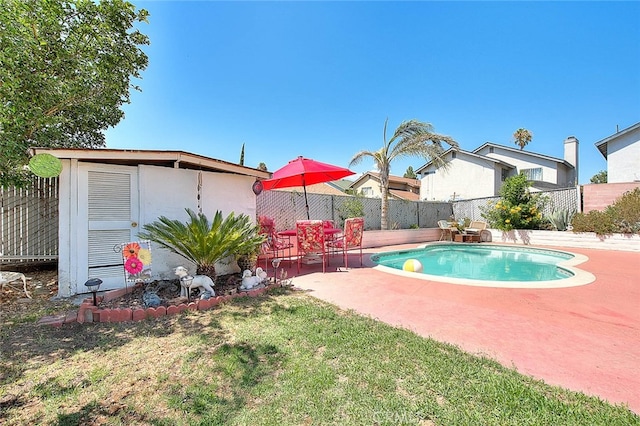 view of pool with a storage shed, a lawn, and a patio area