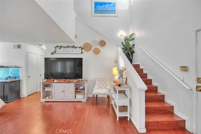 stairs with hardwood / wood-style floors and a textured ceiling