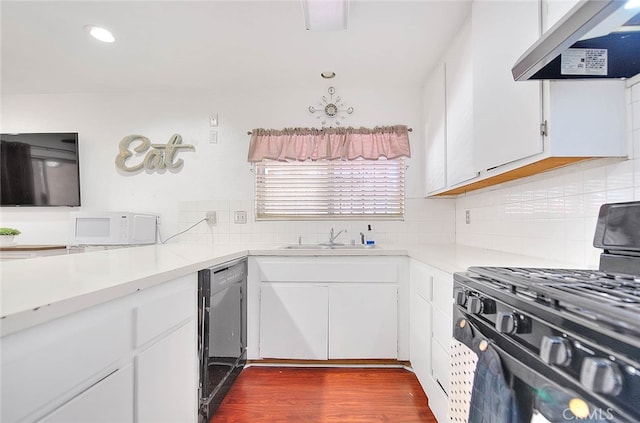 kitchen with white cabinetry, black appliances, ventilation hood, and sink