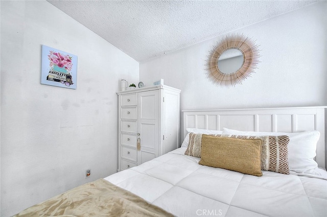 bedroom featuring lofted ceiling and a textured ceiling