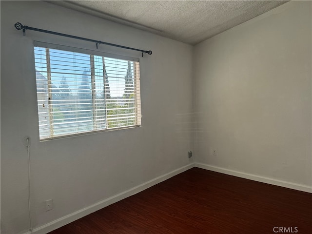 empty room featuring a textured ceiling and wood-type flooring