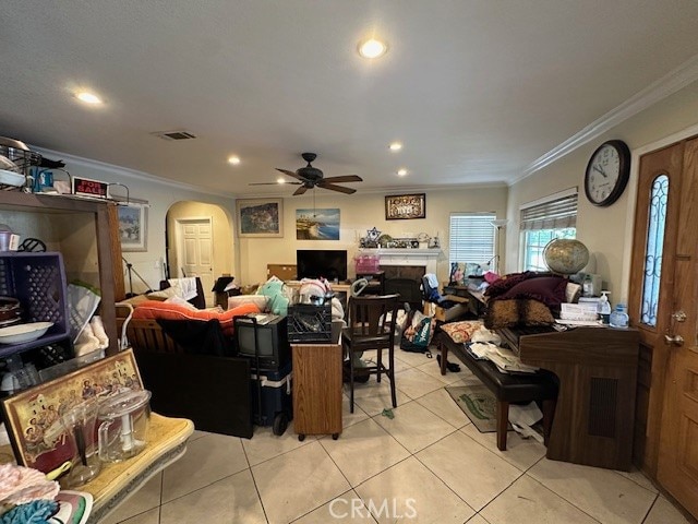 tiled dining room with ornamental molding and ceiling fan