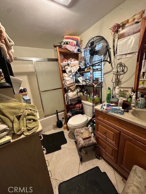 full bathroom featuring vanity, a textured ceiling, tile patterned flooring, shower / bath combination with glass door, and toilet