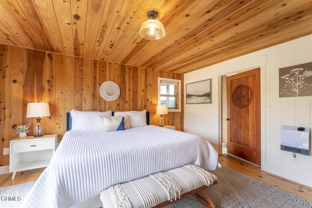 bedroom with heating unit, wooden ceiling, wooden walls, and light hardwood / wood-style floors