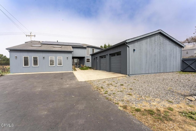 exterior space with a garage and solar panels