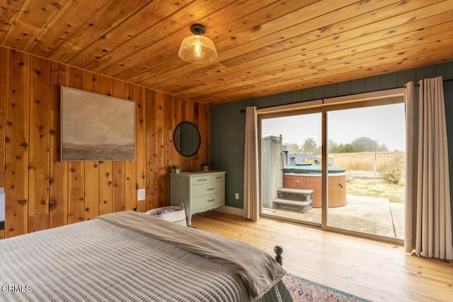 bedroom with access to exterior, wood walls, light hardwood / wood-style flooring, and wood ceiling