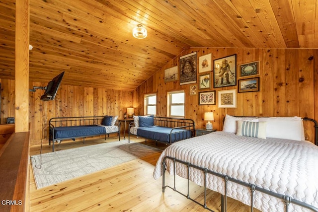 bedroom featuring wooden walls, light hardwood / wood-style flooring, lofted ceiling, and wood ceiling