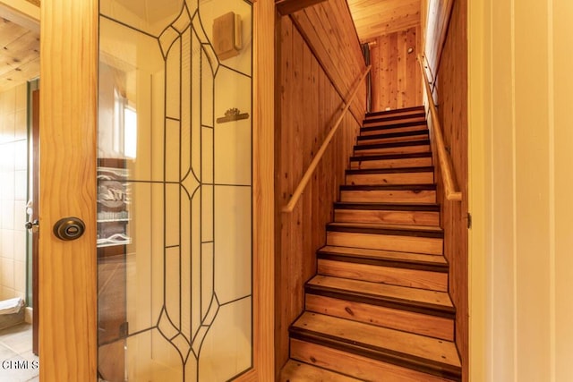 stairs featuring wood walls and wood ceiling