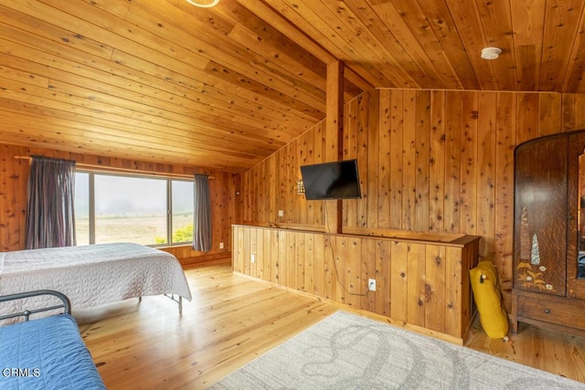 bedroom with wooden ceiling, wooden walls, light hardwood / wood-style floors, and vaulted ceiling