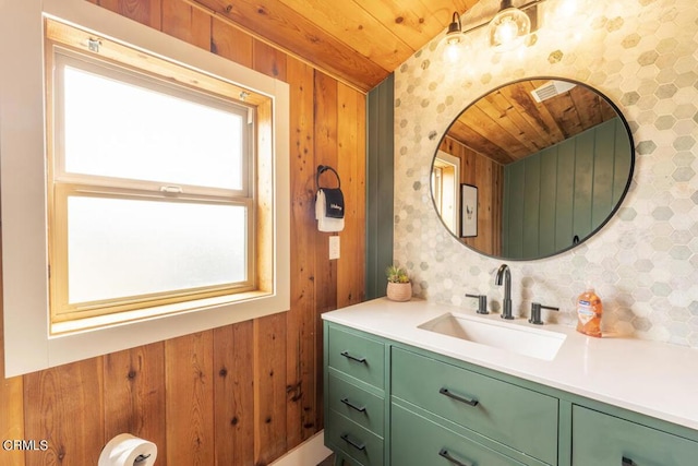 bathroom featuring vanity, wooden walls, and wood ceiling