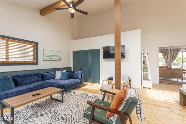 living room featuring hardwood / wood-style flooring, ceiling fan, beamed ceiling, and high vaulted ceiling