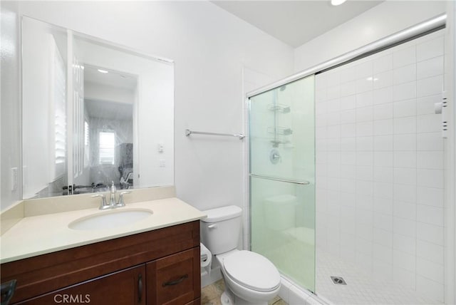 bathroom with walk in shower, vanity, and toilet