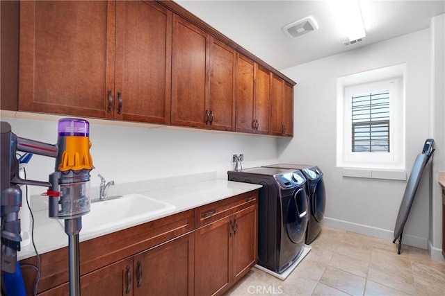 laundry room featuring cabinets, light tile patterned floors, and washing machine and clothes dryer