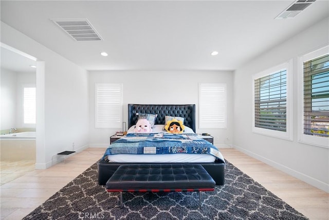 bedroom with light wood-type flooring and multiple windows