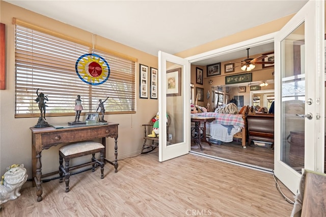 office space featuring light hardwood / wood-style flooring, ceiling fan, and french doors