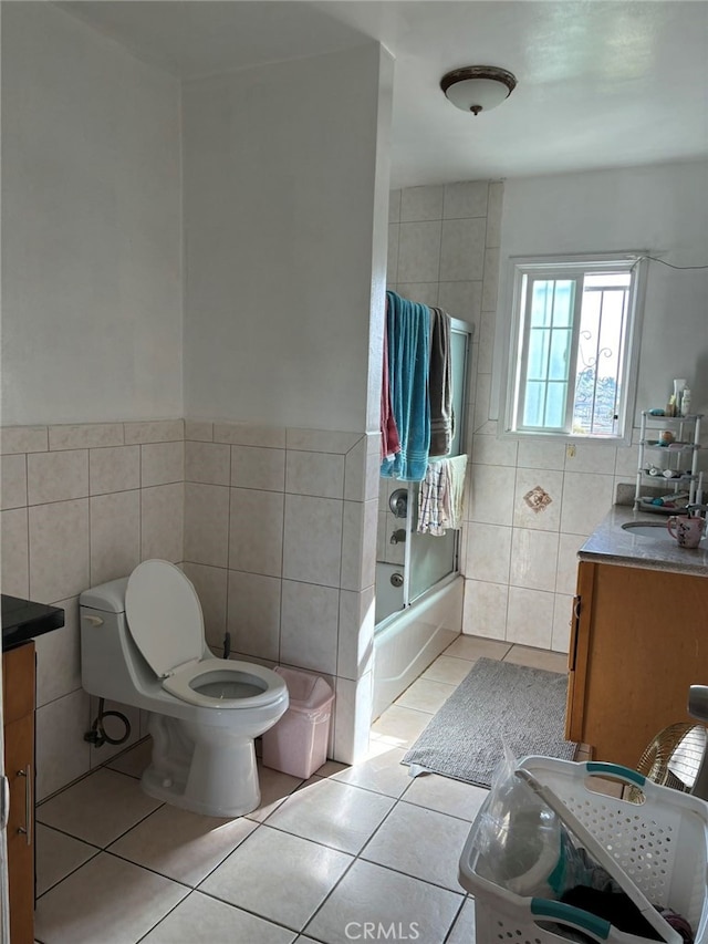 full bathroom featuring tile walls, vanity, toilet, and tile patterned floors