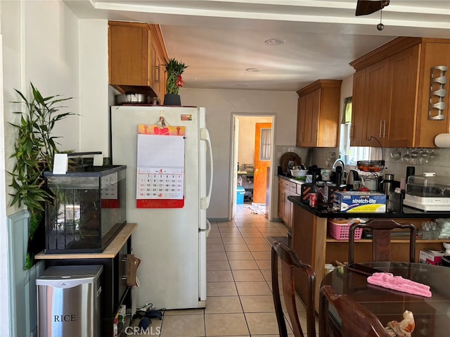 kitchen featuring white refrigerator, backsplash, and light tile patterned flooring