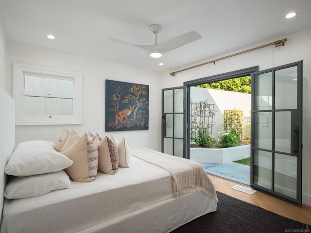 bedroom featuring hardwood / wood-style floors, access to exterior, and ceiling fan