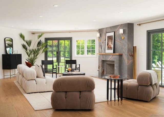 living room featuring french doors, a fireplace, and light wood-type flooring