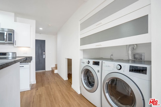 laundry room with washer and dryer and light wood-type flooring