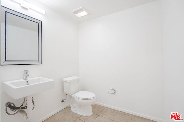 bathroom featuring tile patterned flooring, toilet, and sink