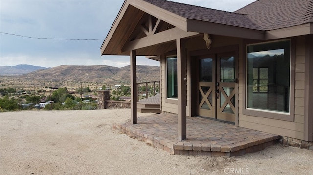 property entrance with a patio, a mountain view, and french doors