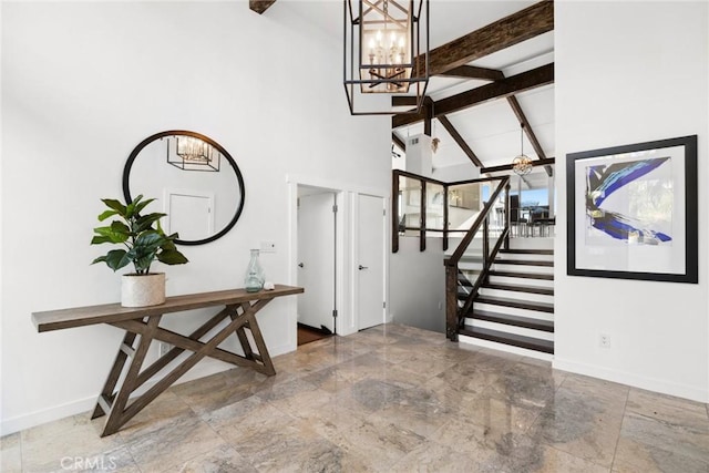 entrance foyer with beam ceiling, high vaulted ceiling, and a chandelier