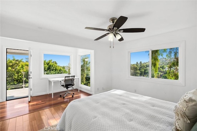 bedroom featuring access to exterior, multiple windows, ceiling fan, and hardwood / wood-style flooring