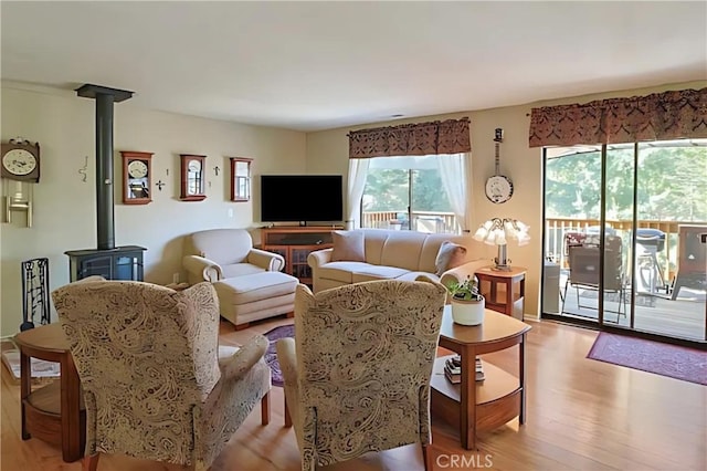 living room featuring light hardwood / wood-style flooring and a wood stove