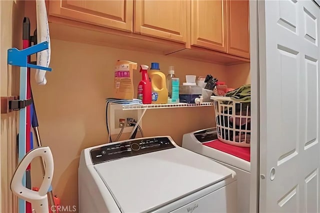 laundry area featuring washing machine and clothes dryer and cabinets