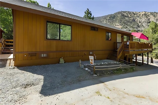 rear view of property featuring a deck with mountain view