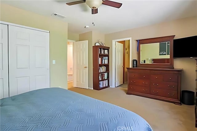 carpeted bedroom with connected bathroom, ceiling fan, and a closet