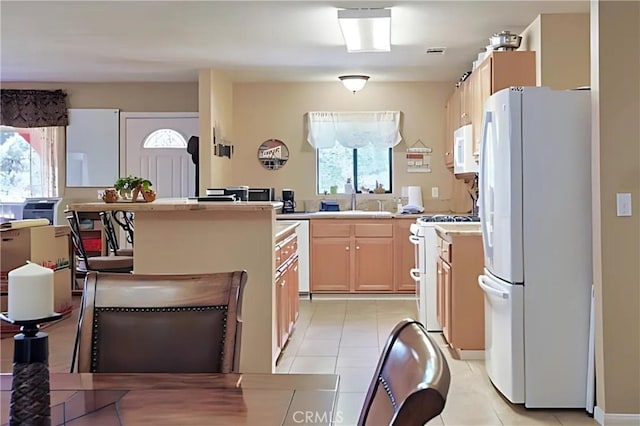 kitchen featuring light brown cabinets, plenty of natural light, sink, and white appliances