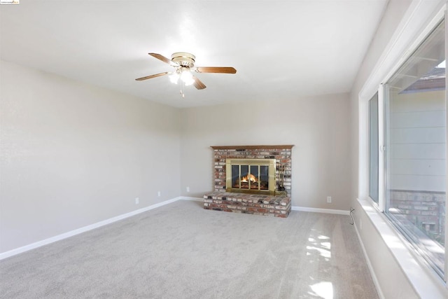 unfurnished living room featuring ceiling fan, light colored carpet, and a brick fireplace