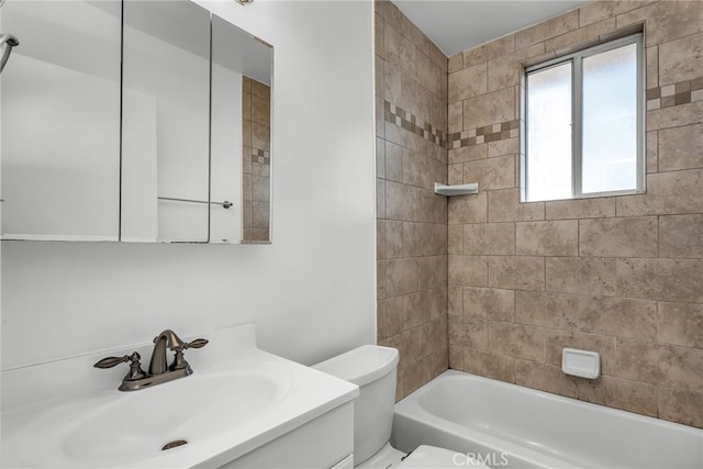 full bathroom featuring vanity, tiled shower / bath combo, and toilet