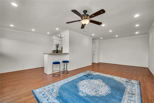 living room with ceiling fan, light hardwood / wood-style flooring, and crown molding