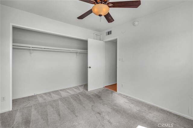 unfurnished bedroom featuring a closet, ceiling fan, and light colored carpet