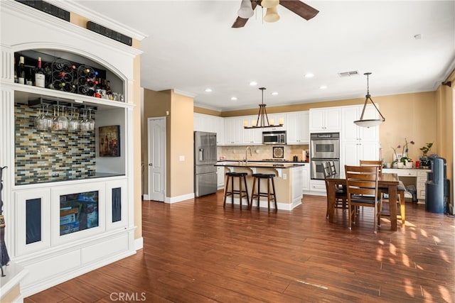 interior space featuring ceiling fan, sink, crown molding, and dark wood-type flooring