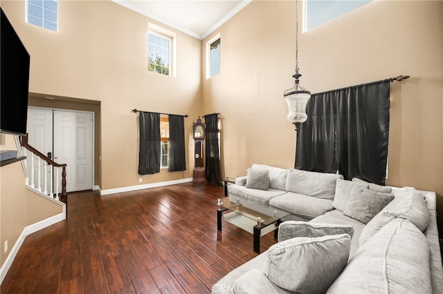 living room featuring ornamental molding, a towering ceiling, and dark hardwood / wood-style floors