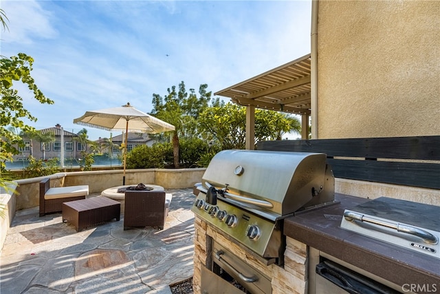 view of patio / terrace featuring a water view, grilling area, and a fire pit