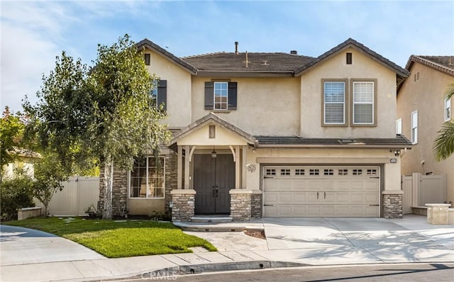 view of front of house featuring stucco siding, stone siding, concrete driveway, and fence