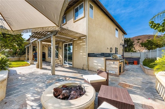 view of patio / terrace featuring area for grilling, a pergola, a fenced backyard, an outdoor fire pit, and a mountain view