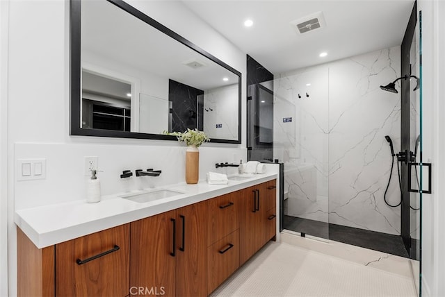 bathroom with vanity and tiled shower