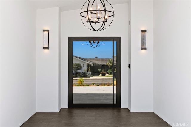 doorway featuring dark wood-type flooring and a chandelier