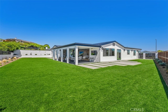 rear view of house featuring a lawn and a patio area